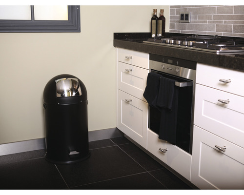 Scène de cuisine avec une poubelle à pédale noire et des armoires de cuisine blanches