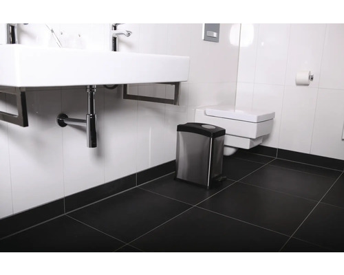 Salle de bain avec lavabo, toilettes et poubelle à pédale