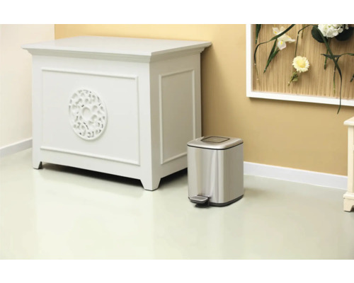 Scène avec commode et poubelle à pédale argentée