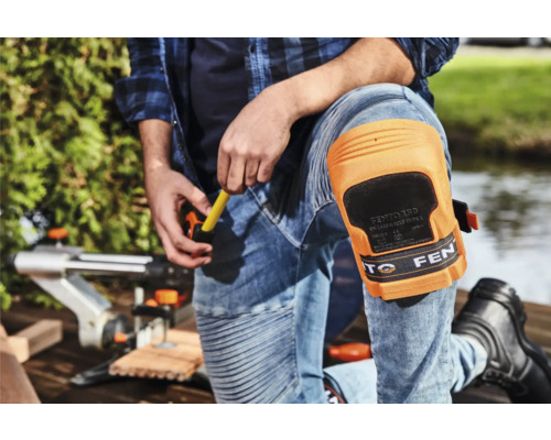 Artisan portant des genouillères travaillant avec une scie sauteuse