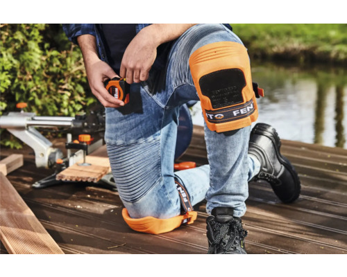 Homme avec genouillères et mètre ruban travaillant le bois