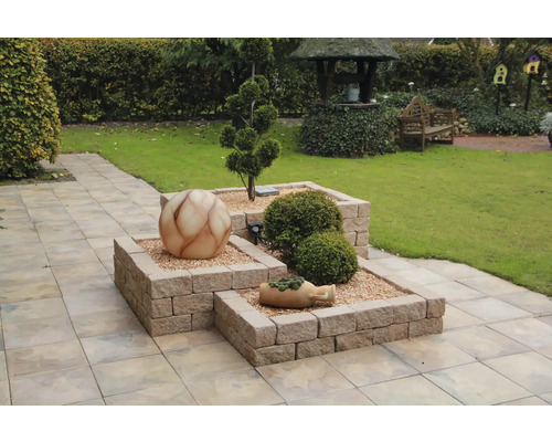 Scène de jardin avec parterres surélevés en briques, boule décorative et plantation