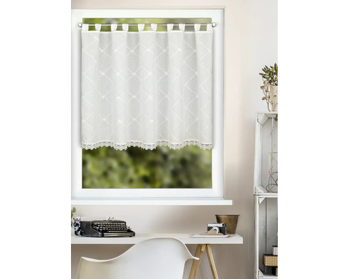 Store de rideau avec suspension à boucles et broderie sur le bord inférieur devant une fenêtre.