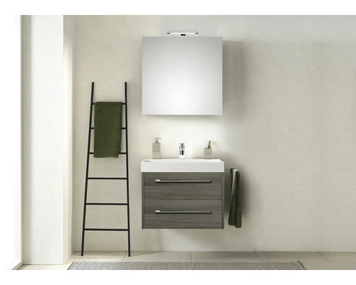 Salle de bains avec lavabo, miroir, serviette et échelle à serviettes.