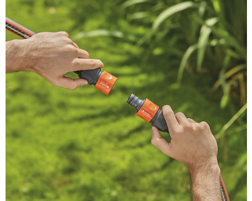 Zwei Hände verbinden eine Gartenschlauchkupplung.