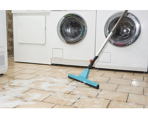 Raclette à plancher devant les machines à laver sur sol carrelé