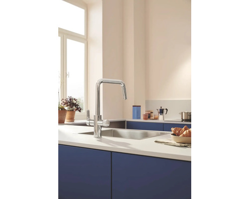 Scène de cuisine avec mitigeur d''évier, évier et ustensiles de cuisine sur un plan de travail