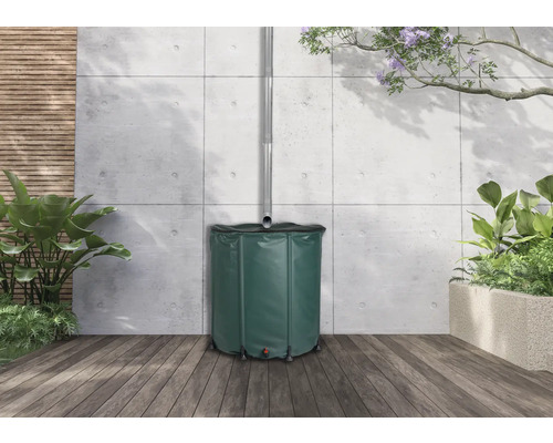 Récupérateur d''eau de pluie en plastique avec tuyau d''évacuation dans le jardin