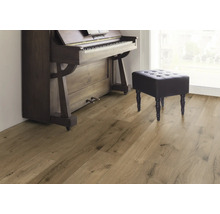 Plancher en bois avec piano et tabouret dans une pièce lumineuse.