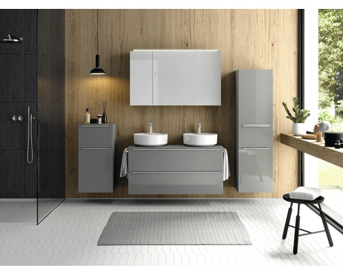 Salle de bains lumineuse avec lavabo, miroir, meuble bas, armoire haute, douche et tabouret.