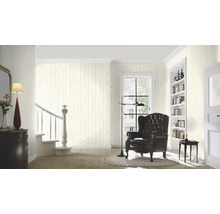 Salon avec papier peint imitation bois, fauteuil et escalier
