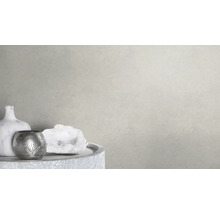 Scène décorative avec vase, bougeoir et pierre ornementale sur une table devant un mur clair