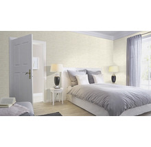Helles Schlafzimmer mit Bett, Nachttisch, Lampe und Tapete im Backsteindesign