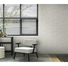Intérieur avec fenêtre, stores, fauteuil et mur à motif de briques