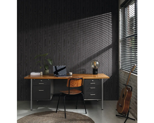 Büro mit Schreibtisch, Stuhl, Lampe, Gitarre und Laptop vor einer dunklen Holzvertäfelung