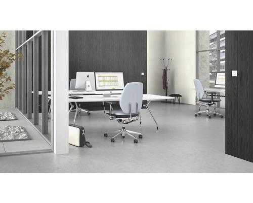 Büro mit Schreibtischen, Bürostühlen und Computern in einem hellen, modernen Raum.