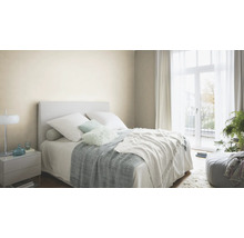 Chambre lumineuse avec lit, table de chevet et rideaux