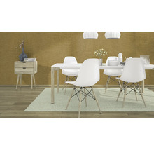 Salle à manger avec table, chaises, commode et décoration devant un mur à motifs