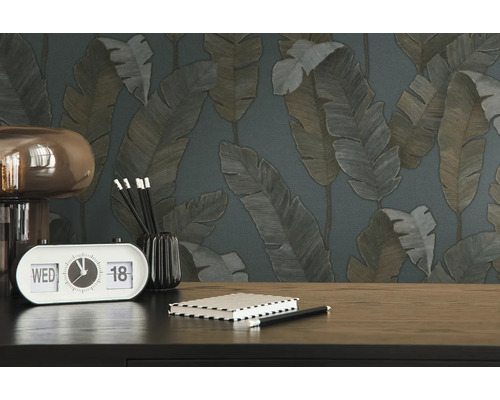 Nahaufnahme eines Tisches mit einer Uhr, einem Notizbuch und einer Tapete mit Blattmuster