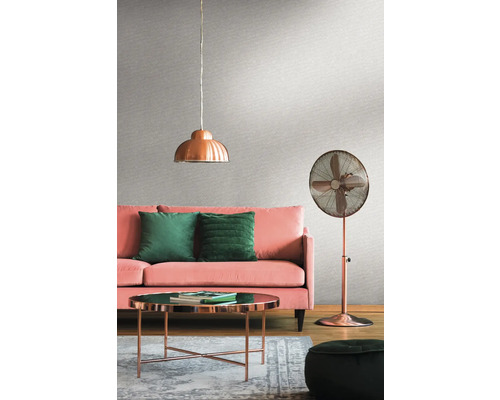 Wohnzimmer mit rosa Sofa, grünen Kissen, Kupferlampe, Kupferventilator und Couchtisch