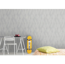 Zimmer mit gemusterter Tapete, Tisch, Stuhl, Skateboard und Bett