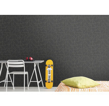 Dekoratives Zimmer mit Mustertapete, Schreibtisch, Stuhl, Skateboard und Bett