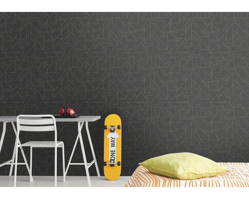 Dekoratives Zimmer mit Mustertapete, Schreibtisch, Stuhl, Skateboard und Bett