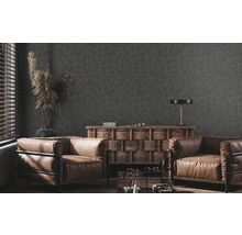 Wohnzimmer mit geometrischer Tapete, Ledersesseln und Holzkommode.