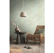Wohnzimmer mit gemusterter Tapete, Rattansessel und Beistelltisch mit Dekoration