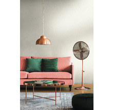 Wohnzimmer mit rosa Sofa, grünen Kissen, kupferfarbenem Tisch, Stehlampe und Pendelleuchte.