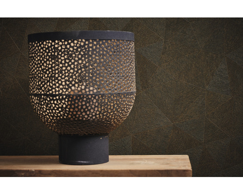 Lanterne décorative en métal avec motif perforé devant un mur à motif géométrique