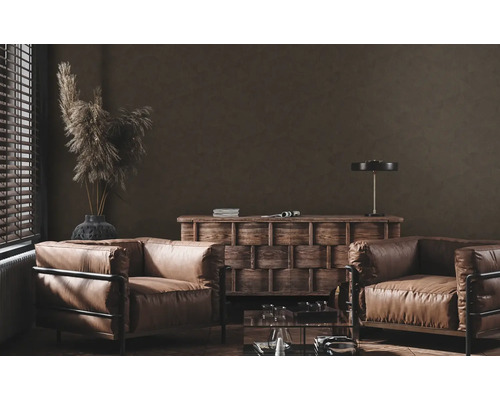 Salon avec deux fauteuils en cuir, commode en bois et éléments décoratifs.