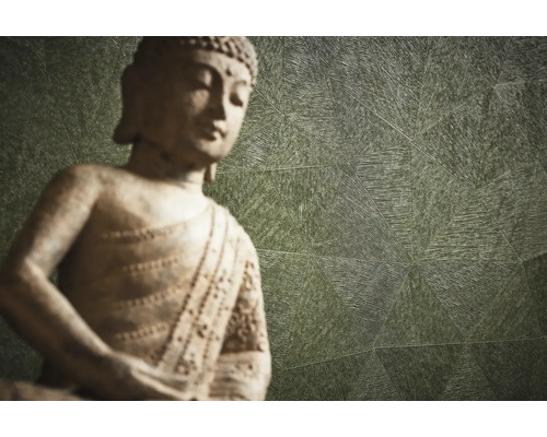 Dekorative Buddha Statue vor einer gemusterten Wand