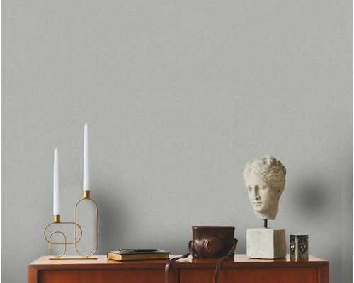 Intérieur décoratif avec papier peint, bougeoir, buste et caméra vintage sur une commode