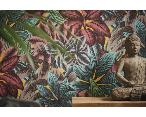 Pièce avec papier peint à feuilles tropicales et statue de Bouddha