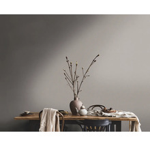 Tischdekoration mit Geschirr und Vase vor gestrichener Wand