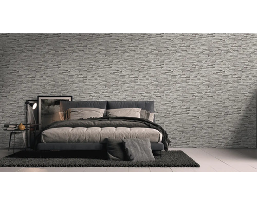 Chambre à coucher avec papier peint imitation pierre, lit et table de chevet