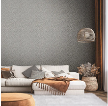 Wohnzimmer mit gemusterter Tapete, Sofa und Dekorationen für ein gemütliches Ambiente