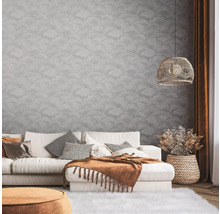 Wohnzimmer mit Sofa, Kissen, Decke, Lampe und dekorativer Wandgestaltung für eine stilvolle Atmosphäre.