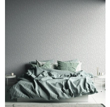 Schlafzimmer mit Bett, Nachttischen und gemusterter Tapete