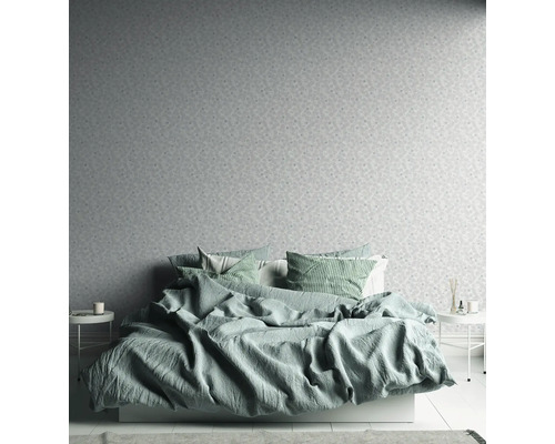 Schlafzimmer mit Bett, Nachttischen und gemusterter Tapete