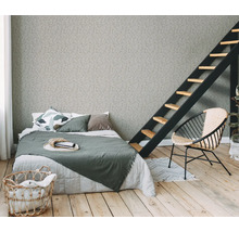 Schlafzimmer mit Bett, Leiter, Sessel und Wäschekorb auf Holzboden