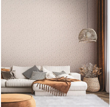 Wohnzimmer mit Couch, Kissen, Decke, Lampe und floral gemusterter Tapete