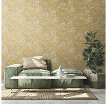 Wohnzimmer mit gelber Blumentapete, Sofa, Tisch und Zimmerpflanze
