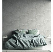 Schlafzimmer mit floral gemusterter Tapete und Bett