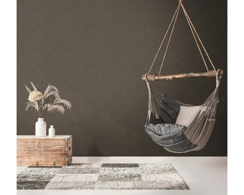 Fauteuil suspendu avec coussin, tapis et décoration dans une pièce