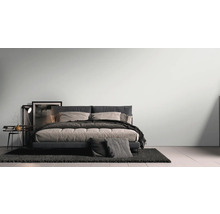 Chambre moderne avec lit, table de chevet et tapis pour une ambiance lumineuse et spacieuse