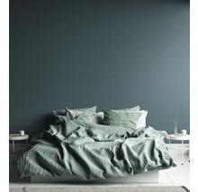 Schlafzimmer mit Bett, Kissen und Beistelltischen