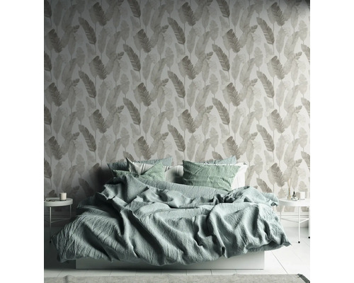 Chambre à coucher avec lit et papier peint à motifs de feuilles