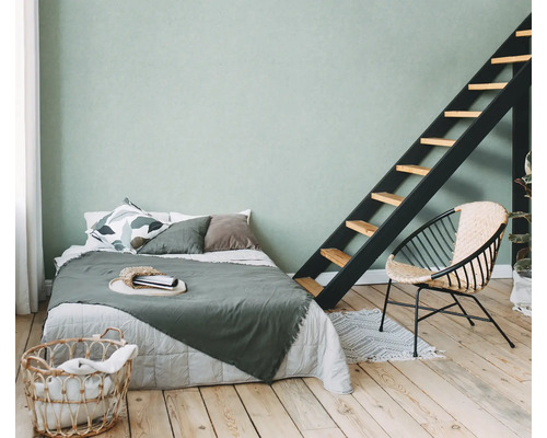 Helles Schlafzimmer mit Bett, Leiter, Stuhl und Wäschekorb auf Holzboden